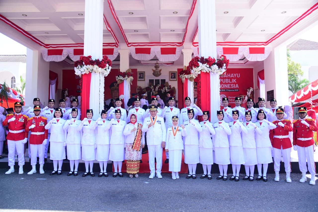 Gubernur Gorontalo Gusnar Ismail dan Ketua Tim Penggerak PKK serta Wakil Gubernur Gorontalo Idah Syahidah Rusli Habibie bersama Pasukan Pengibar Bendera Pusaka (Paskibraka) Gorontalo yang bertugas pada penaikan bendera HUT ke-80 RI di halaman rumah jabatan gubernur, Minggu (17/8/2025). Foto – Humas Diskominfotik