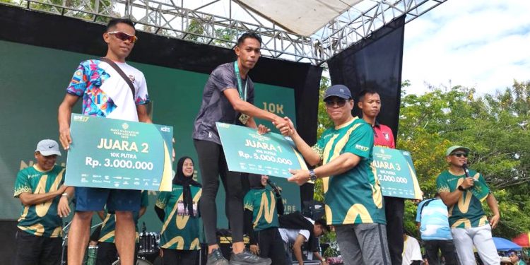 Sekda Iwan Mustapa memberikan sambutan sekaligus menyerahkan bonus kepada tiga pelari tercepat kategori 10 kilometer pada kegiatan Nani Wartabone Heritage Run 2025, di Alun-Alun Bone Bolango, Minggu (24/8/2025).(Humas Kominfo BonBol)
